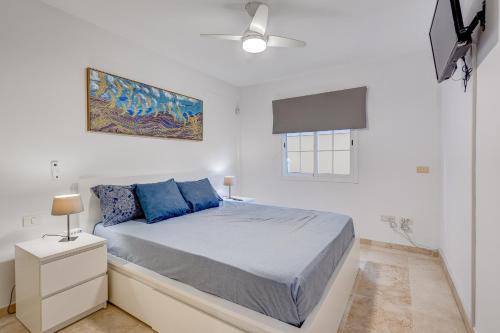 滨海帕尔姆Paraiso Palm Mar Precioso & luminoso apartamento reformado con aire acondicionado的白色卧室配有蓝色枕头的床