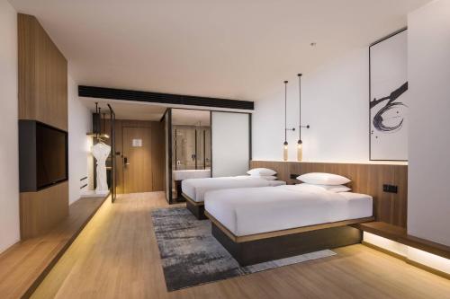 西安西安北站万枫酒店的酒店客房设有三张床和电视。