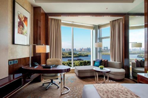 哈尔滨哈尔滨JW万豪酒店的酒店客房配有一张床、一张书桌和一张沙发。