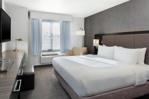史泰登岛Fairfield Inn & Suites by Marriott New York Staten Island的一间设有大床和窗户的酒店客房