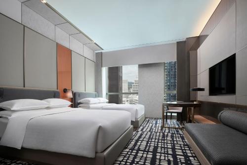 深圳深圳博林天瑞喜来登酒店的酒店客房设有三张床和电视。