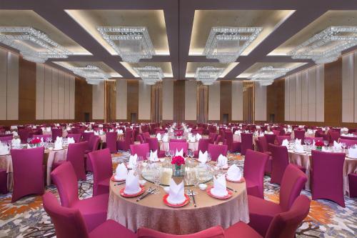 秦皇岛秦皇岛北戴河喜来登酒店的一个带紫色桌椅的大型宴会厅