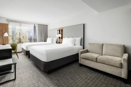 纽约Fairfield Inn & Suites by Marriott New York Manhattan/Times Square South的酒店客房,设有两张床和一张沙发