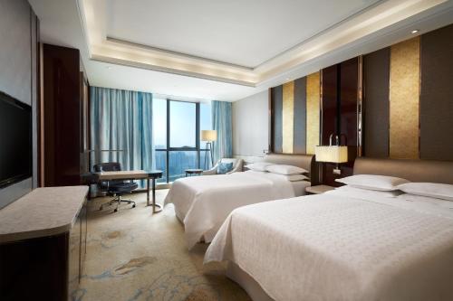 郑州郑州美盛喜来登酒店的酒店客房设有两张床和电视。
