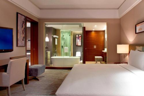 太仓太仓宝龙福朋喜来登酒店的一间卧室配有一张床,浴室设有浴缸
