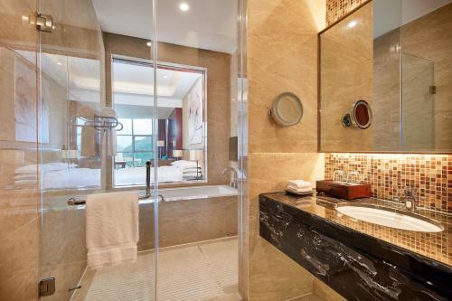 水城六盘水福朋喜来登酒店的一间带玻璃淋浴和水槽的浴室