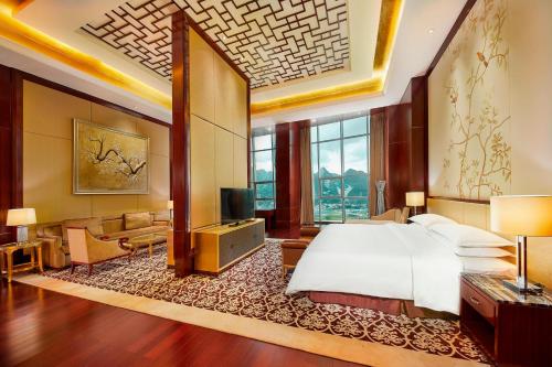 水城六盘水福朋喜来登酒店的一间卧室设有一张床和一间客厅。