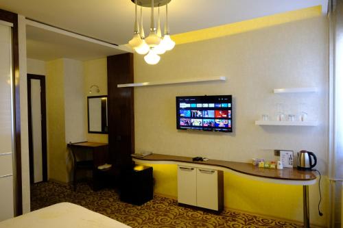 代尼兹利爱斯酒店的酒店客房设有一张桌子和一台墙上的电视。