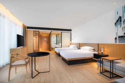 太原太原南站万枫酒店的酒店客房设有两张床和一张桌子。