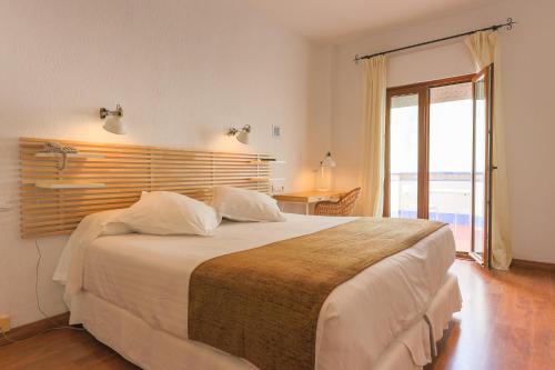 圣玛丽亚港洛斯坎塔洛斯酒店的卧室配有一张白色的大床和一张桌子