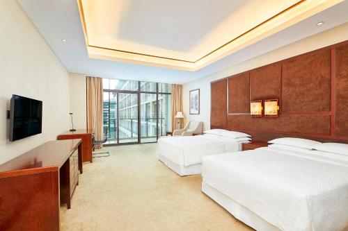 儋州儋州福朋喜来登酒店的酒店客房设有两张床和电视。