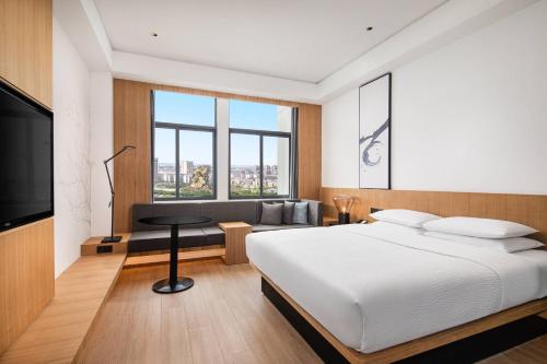 荆州荆州万枫酒店­­的一间卧室配有一张床、一张沙发和一台电视
