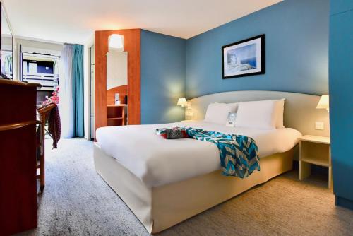 拉尼翁基里雅德拉尼翁-佩罗斯-皮若斯酒店的一间卧室配有一张白色大床和蓝色的墙壁