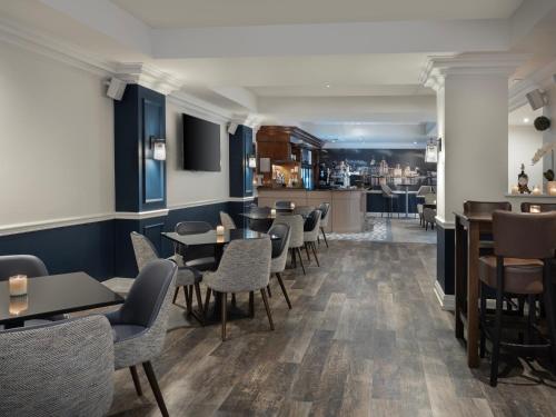利物浦Delta Hotels by Marriott Liverpool City Centre的一间带桌椅的餐厅和一间酒吧