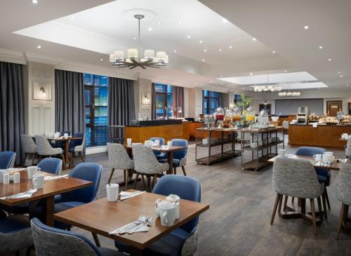 利物浦Delta Hotels by Marriott Liverpool City Centre的一间带桌椅的餐厅和一间酒吧