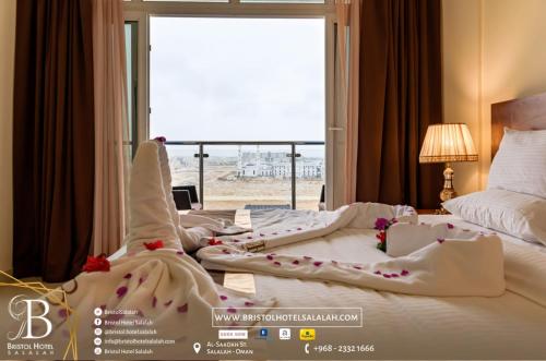 塞拉莱Bristol Hotel Salalah的酒店客房设有两张床和大窗户。