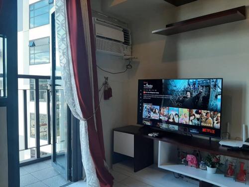 宿务Horizons 101 Condominium的客厅配有平面电视和窗户。