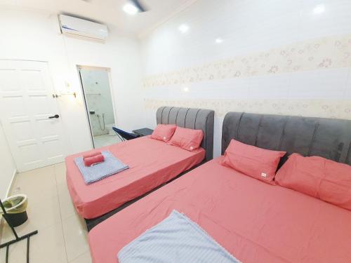 芙蓉Lot 90 Seremban Town Homestay的宿舍间内的两张床,配有红色枕头