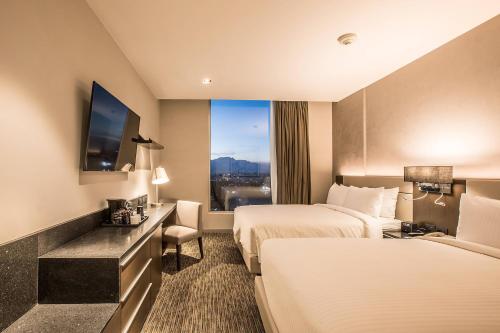 普埃布拉Four Points by Sheraton Puebla的酒店客房设有两张床和窗户。