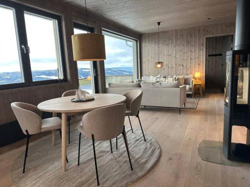 哈山Hafjell - Penthouse - ski in/out的客厅配有桌椅和沙发