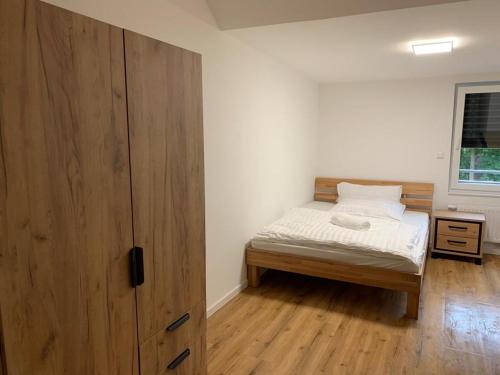 平讷贝格Gasthaus Pinneberg的一间卧室配有一张床和一个大型木制橱柜