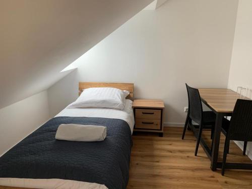 平讷贝格Gasthaus Pinneberg的一间卧室配有一张床、一张桌子和一张桌子