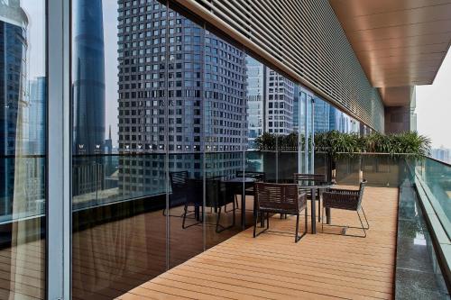 广州W Guangzhou的大楼内的阳台配有桌椅