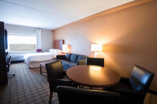温尼伯南温尼伯喜来登福朋酒店的酒店客房设有沙发、床和桌子。