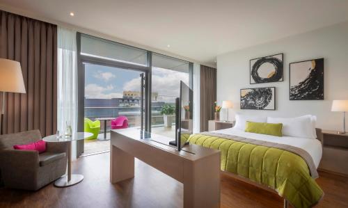 都柏林吉普森酒店的一间卧室配有一张床、一张书桌和一个窗户。