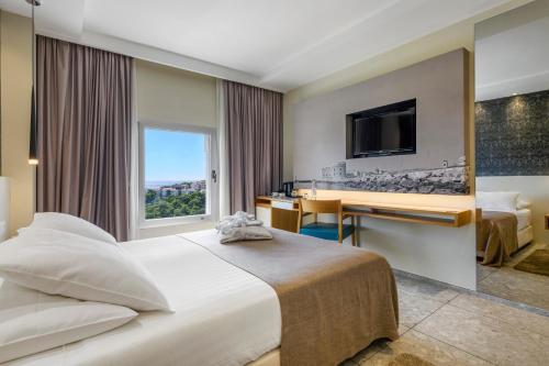 杜布罗夫尼克莱拉酒店的酒店客房配有一张床、一张书桌和一台电视。