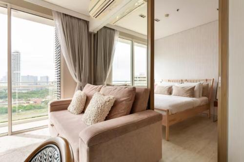 纳仲天Family Suite Sea view 2Bedroom at Veranda Residence Pattaya的一间带沙发和一张镜子的床的卧室