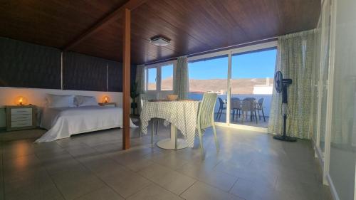 塔拉哈勒赫Tarajalejo Eco C的一间卧室配有一张床和一张桌子,享有美景
