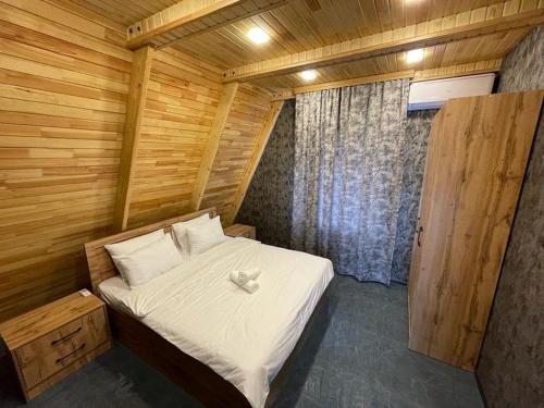 盖贝莱Qafqaz Eminent Chalet的木制客房内的一间卧室,配有一张床