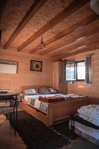 瓦列沃Prenoćište Lelić的木制客房内的一间卧室配有两张床