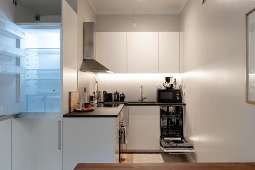 赫尔辛基FREDA - Relaxing downtown studio的厨房配有白色橱柜和黑色台面