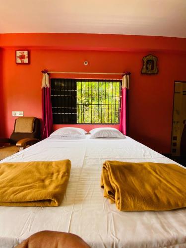 MādangeriGokarna cross stay的一间卧室配有一张床铺和两张毯子