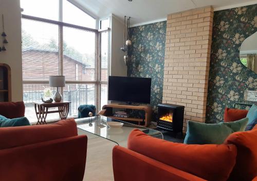 奥赫特拉德Willow Lodge Auchterarder的一间带电视和壁炉的客厅