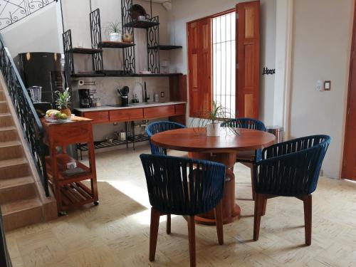 坎佩切Hotel Casa Piedad的一间带木桌和椅子的用餐室