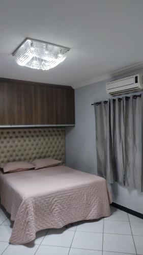 瓦拉达里斯州长市Casa bairro Tiradentes的一间卧室配有一张床和一个吊灯