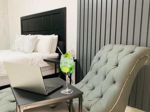 温特和克Essence Lifestyle Self-Catering Accommodation的一间卧室配有一张床、一张桌子、一台笔记本电脑和一把椅子