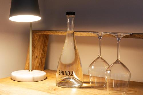 塞维利亚Casa Alhaja by Shiadu的桌子上放有一瓶和两杯酒