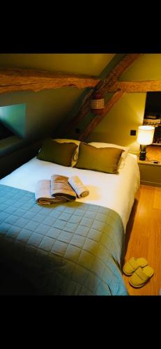 1h40 de paris - le perche - Normandie的一间卧室配有带毛巾和拖鞋的床。