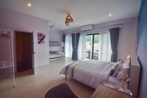 华欣Neverland Hua Hin - Beach Retreat Home的一间卧室设有一张床和一个大窗户