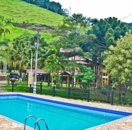 德尔芬莫雷拉hotel fazenda das montanhas的一座山屋前的游泳池