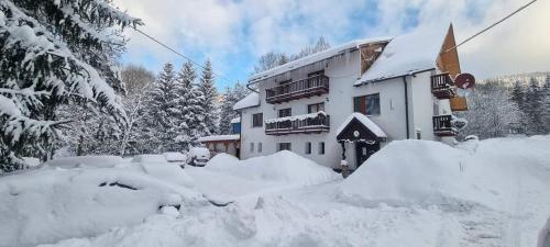 扎兹里瓦Penzion Zázrifka的一座积雪覆盖的建筑,周围积雪很多