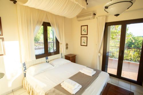 苏尼翁Villa Sounio的一间卧室配有一张带白色床单和窗户的床。