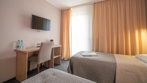 华沙佳雅酒店的酒店客房配有书桌和床。
