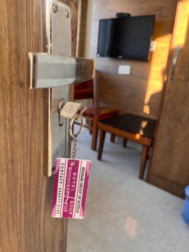 钱德加尔Hotel Woodcrest Zirakpur Chandigarh- Best Family Hotel的挂在门上的标签,带有钥匙