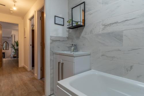 切斯特Luxury Chapel Apartment within City Walls的白色的浴室设有浴缸和水槽。