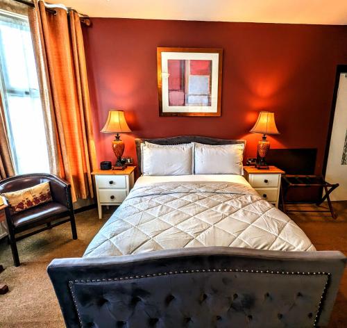 切斯特Brookside Hotel & Restaurant ,Suitable for Solo Travelers, Couples, Families, Groups Education trips & Contractors welcome的一间卧室配有一张红色墙壁的床和两盏灯。